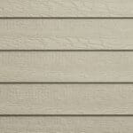 Close-up of beige horizontal wooden siding panels with a textured, wood grain pattern. The panels are evenly spaced and create a repeating linear design.