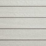 Close-up of beige horizontal wooden siding with visible grain texture and slight shadow lines between each board.