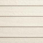 Textured beige horizontal wooden siding panels forming part of an exterior wall, with subtle wood grain patterns visible on each plank.