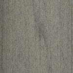 Close-up of a wood grain texture in muted grayish-green tones, showing vertical lines and natural patterns typical of wooden surfaces.