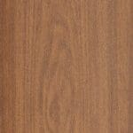 A close-up view of a wooden surface with a smooth texture and natural brown wood grain patterns.
