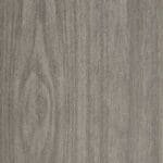 A close-up of a gray wood texture with visible grain patterns and a subtle knot on the left side. The surface has a natural, matte finish.