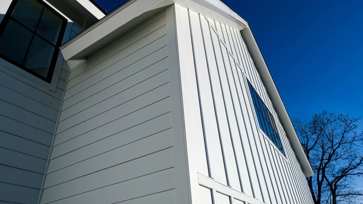 Completed white fibre-cement siding installation on a residential home corner