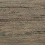 A close-up view of a wooden surface with a weathered, grayish-brown color and natural grain patterns running horizontally.