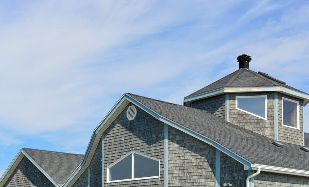A close-up of a modern house with gray wooden shingles