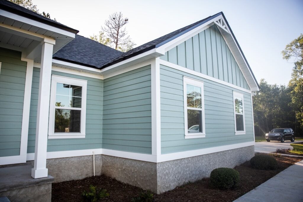 A light blue house with white trim and multiple windows