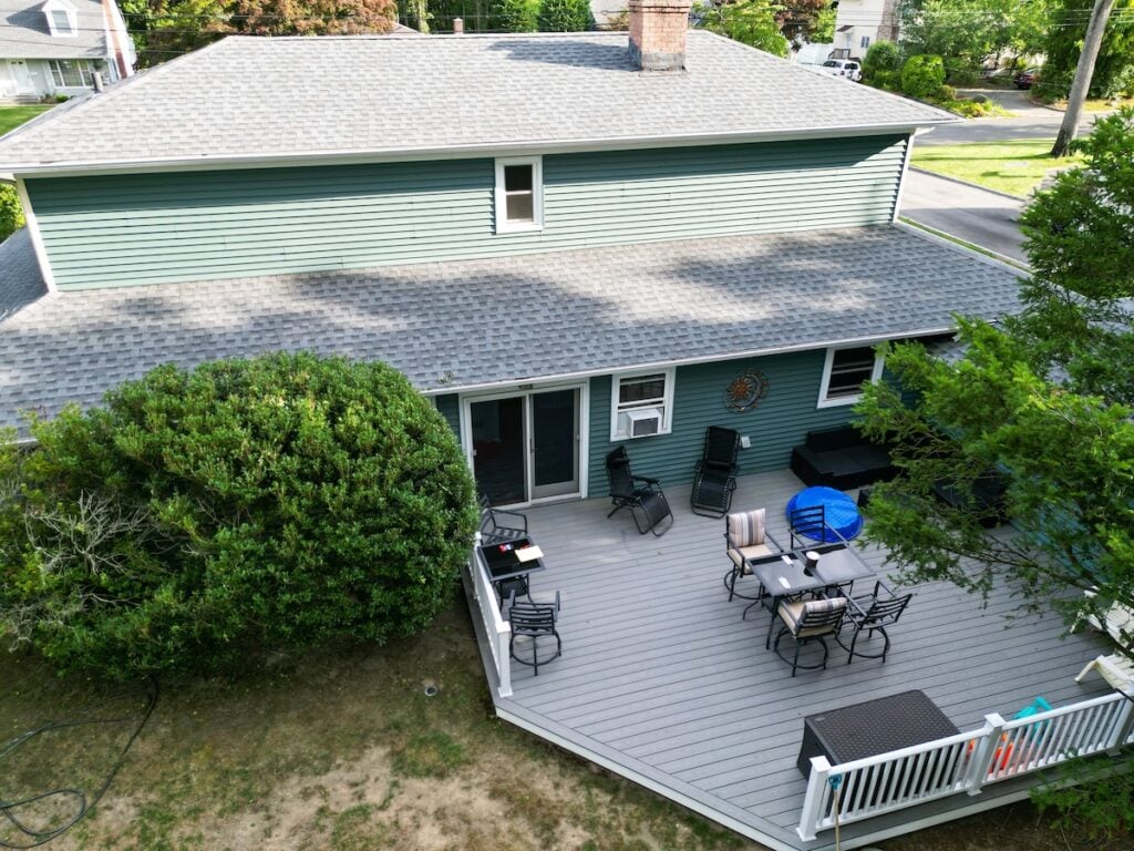 Looking down at backyard with a composite deck on a residential house from a drone.