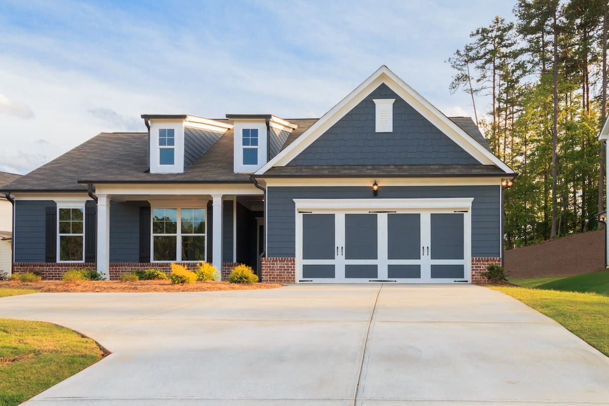 New construction home with blue-grey siding, white trim, and architectural shingle roof