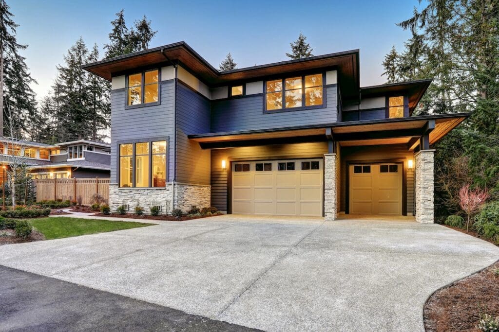 Modern two-story house with large windows, dark wood LP SmartSide siding colors, stone accents, and a double garage