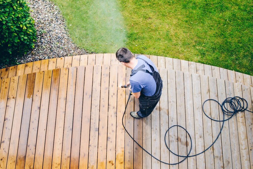 man cleaning terrace with a power washer