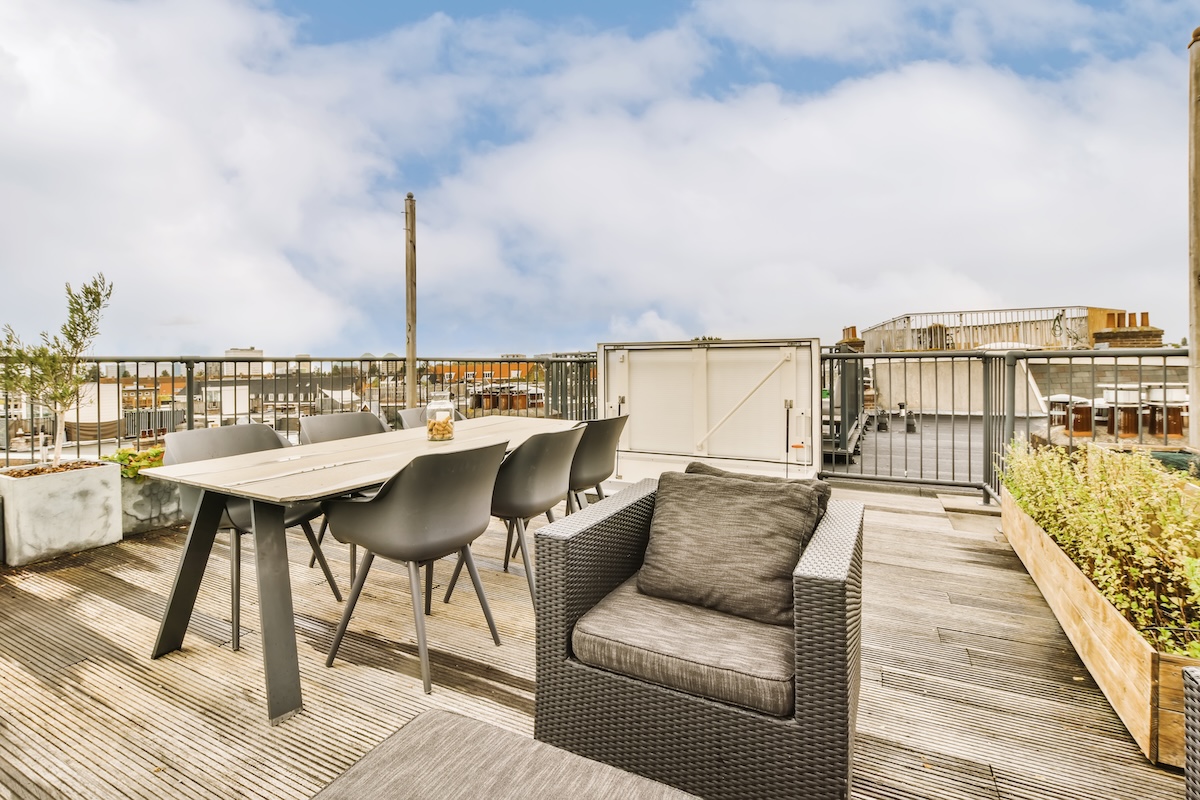 a deck with a table and chairs on a roof
