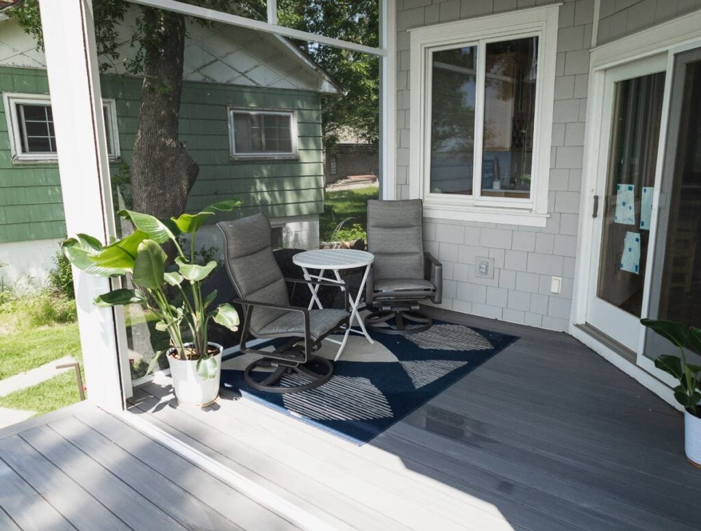 A cozy porch with two gray cushioned chairs