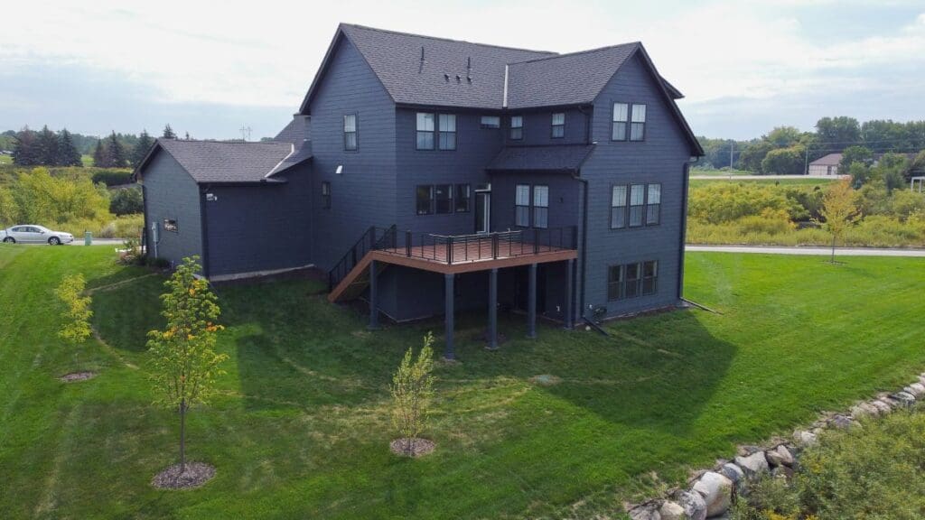 A modern dark gray house with deck