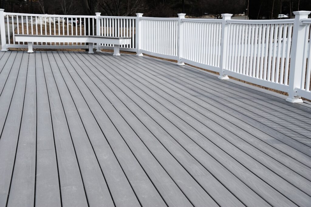 A spacious outdoor deck with gray wooden flooring
