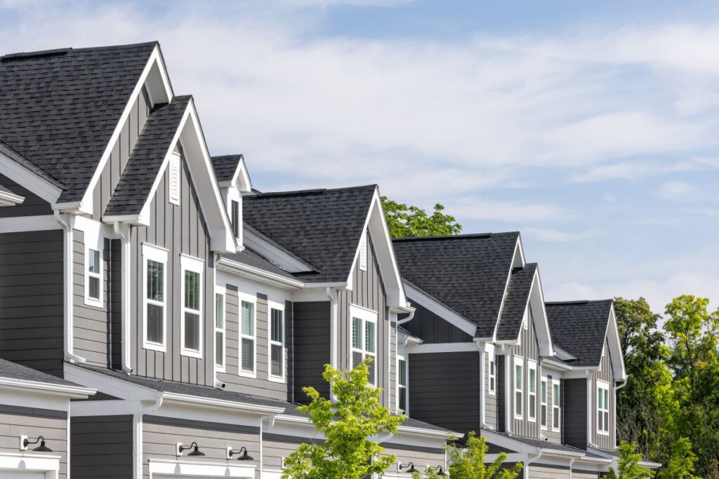 A row of modern gray townhouses with board and batten siding